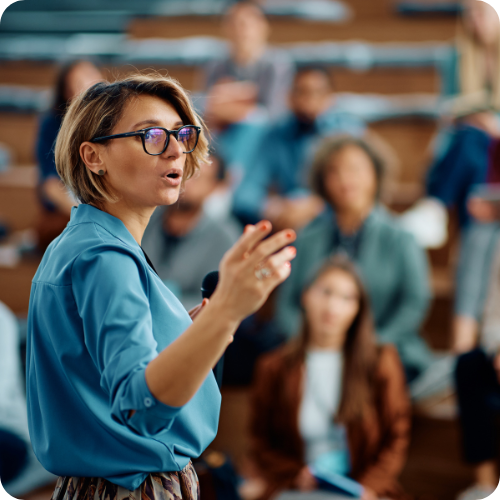 A woman delivering a talk to a room full of people, symbolising ARKK's leadership and expertise.