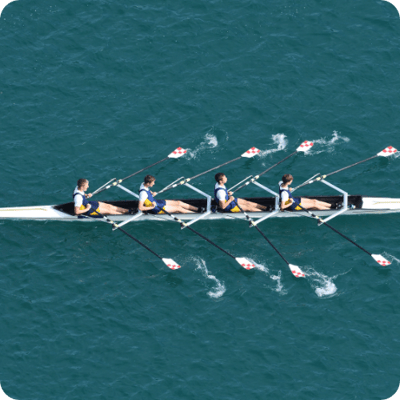 Four men rowing in synchrony, representing how ARKK’s tax automation solution aligns teams for efficient and unified compliance.